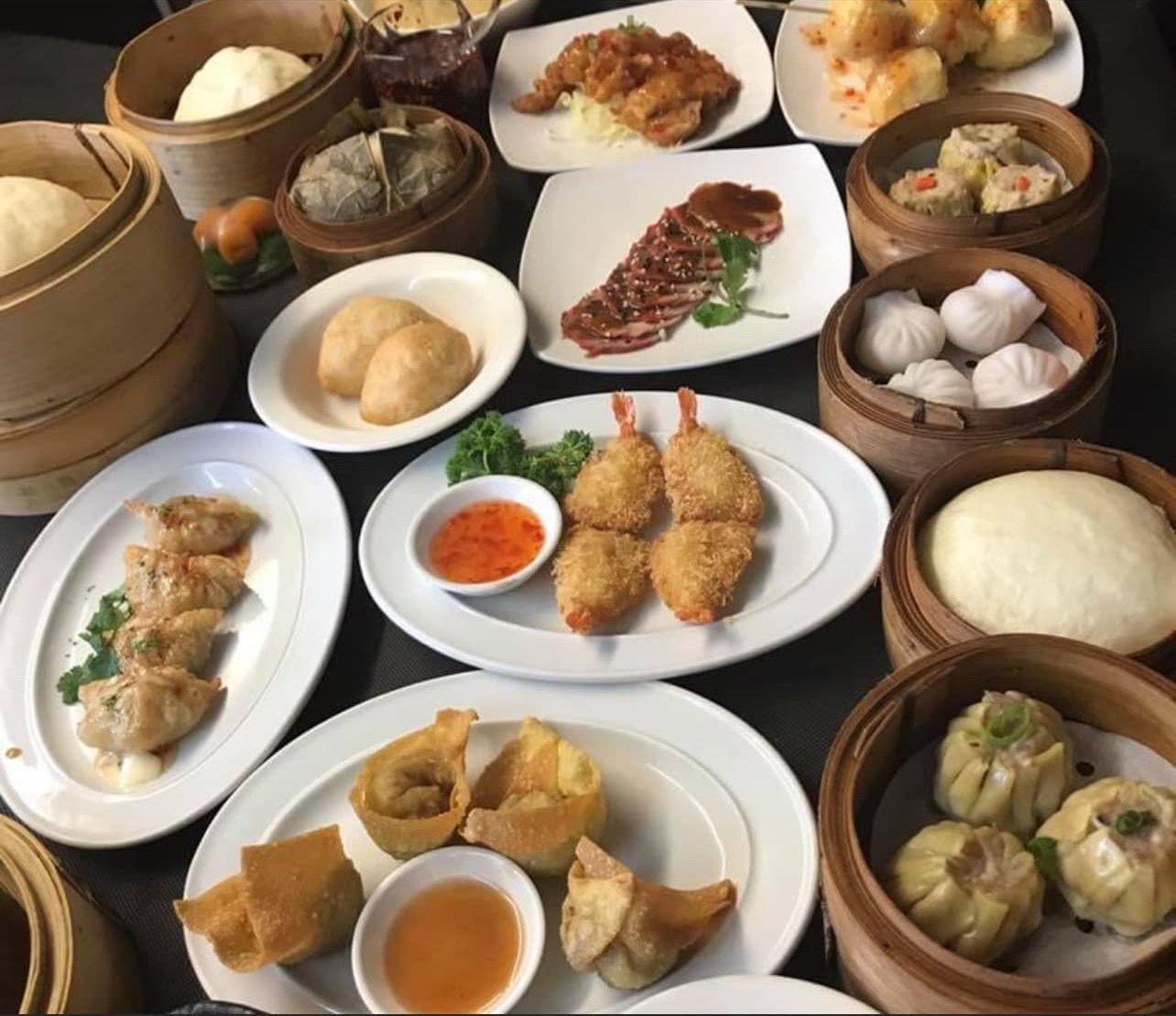 A table topped with many different types of food including dim sum
