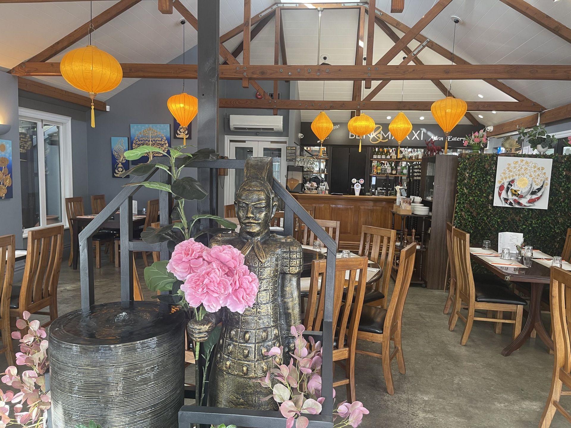 A restaurant with tables and chairs and a statue in the middle