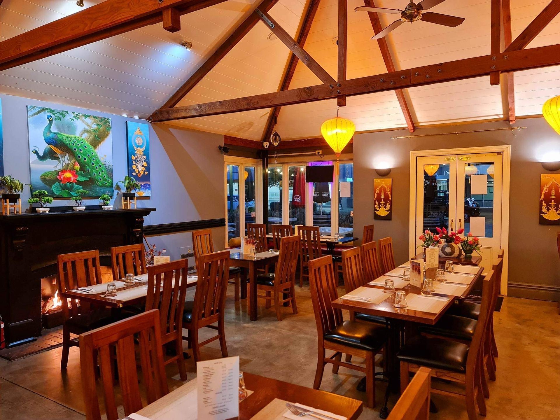 A restaurant with tables and chairs and a ceiling fan