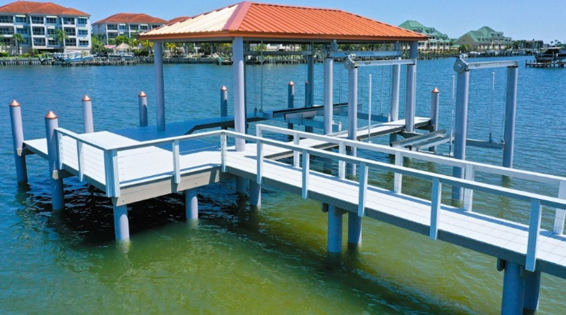 Dock over water with covered seating area and boat lift.
