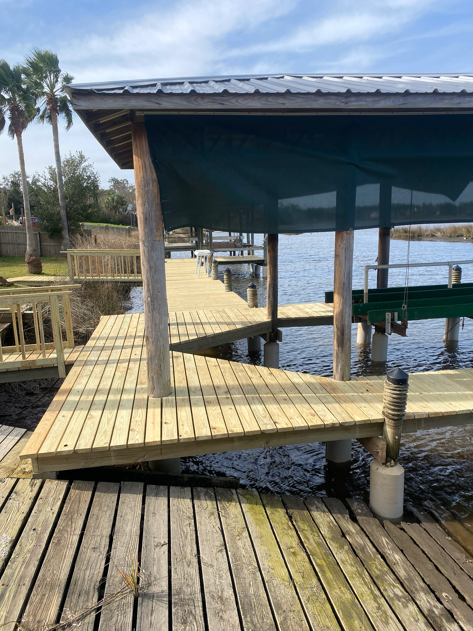Wooden dock with a shaded boat slip extending into the water.