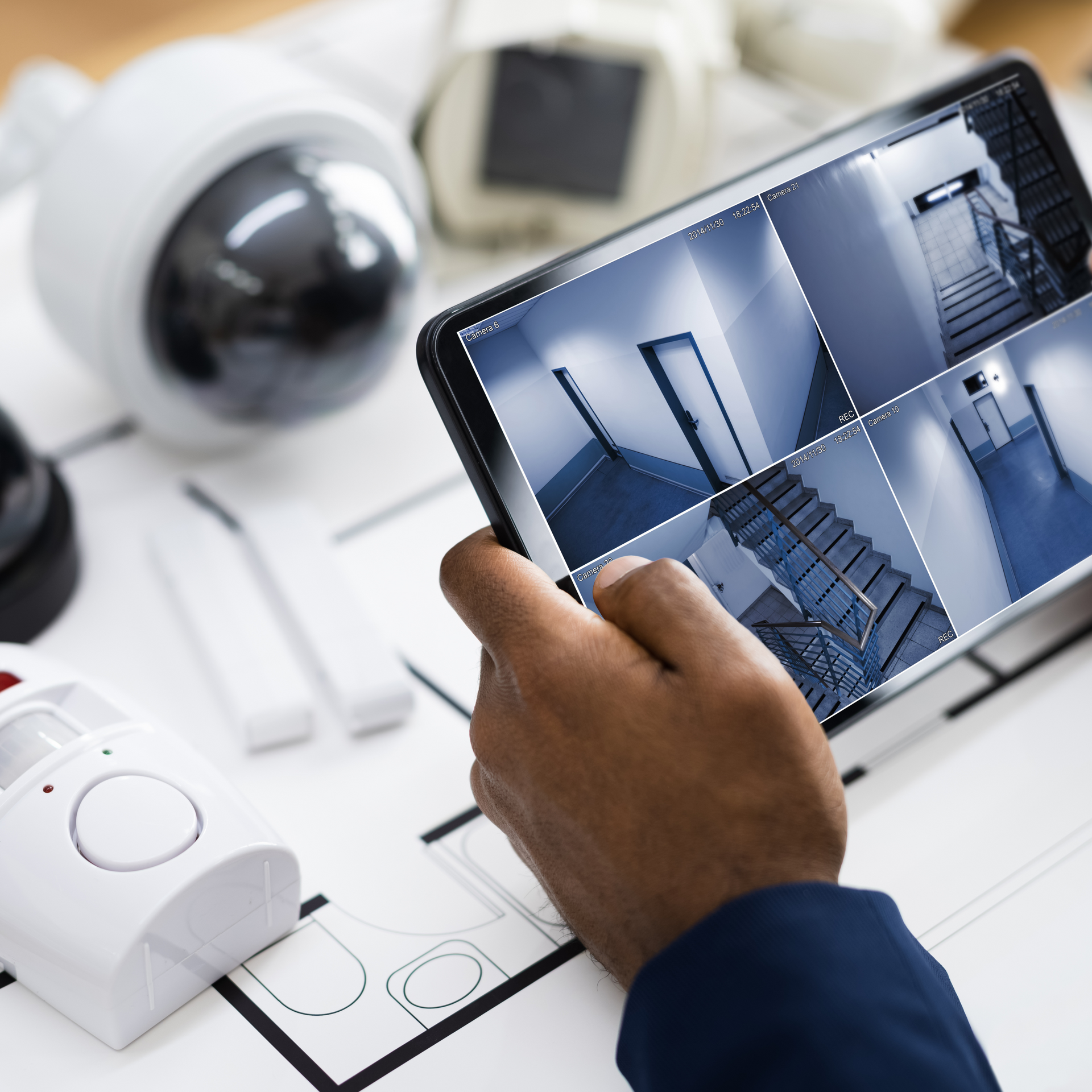 A person is holding a tablet with a picture of a staircase on it