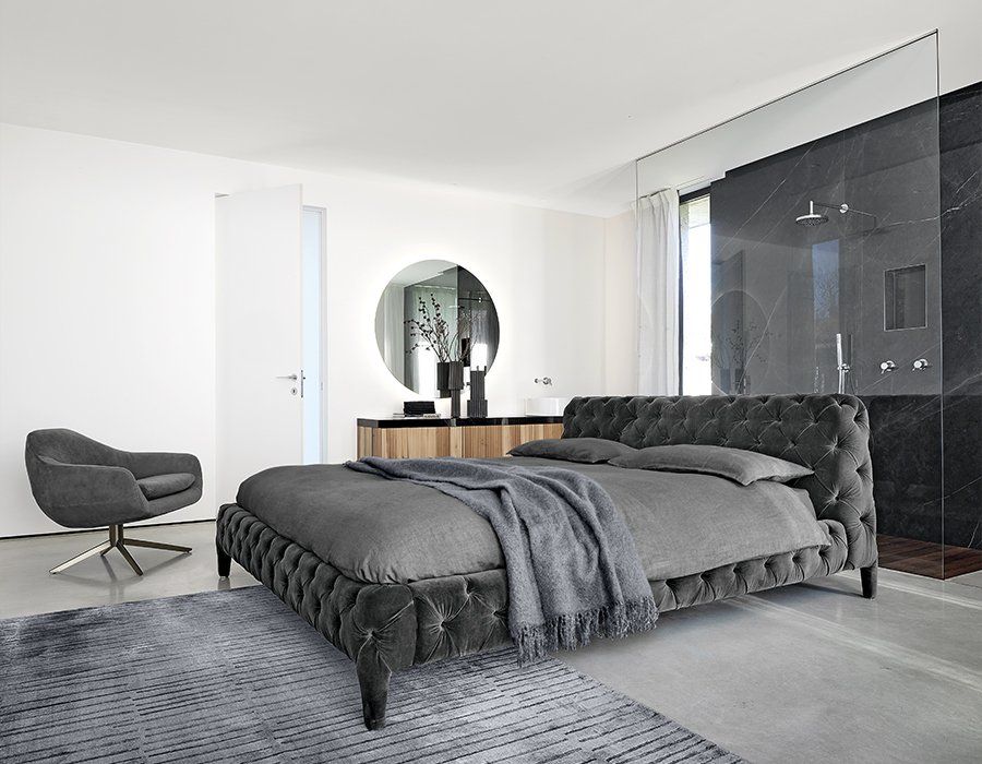 camera con letto grigio e parete color panna
