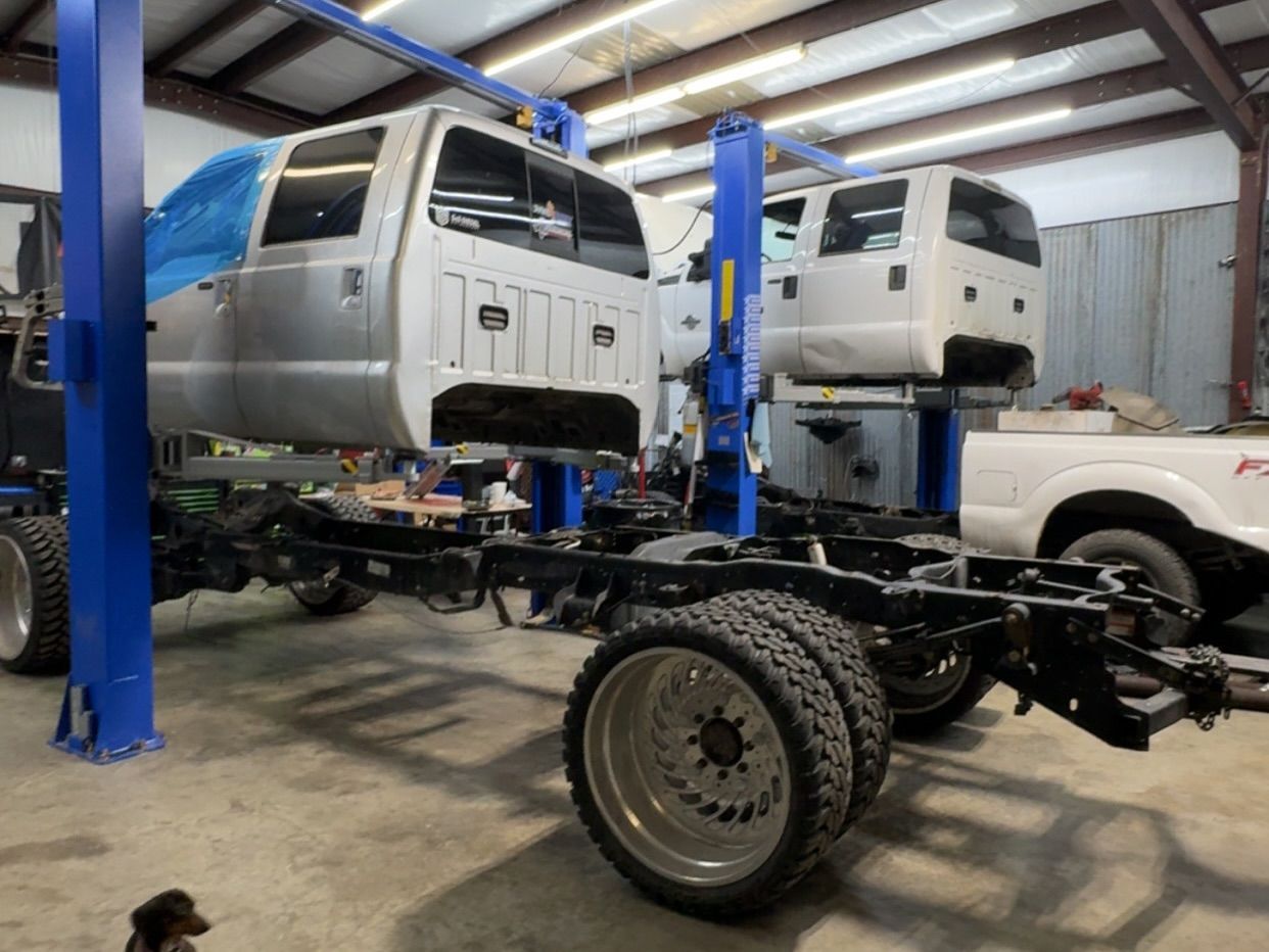 Two Truck Cabs on Lifts Inside The Auto Shop | Flo Diesel Performance