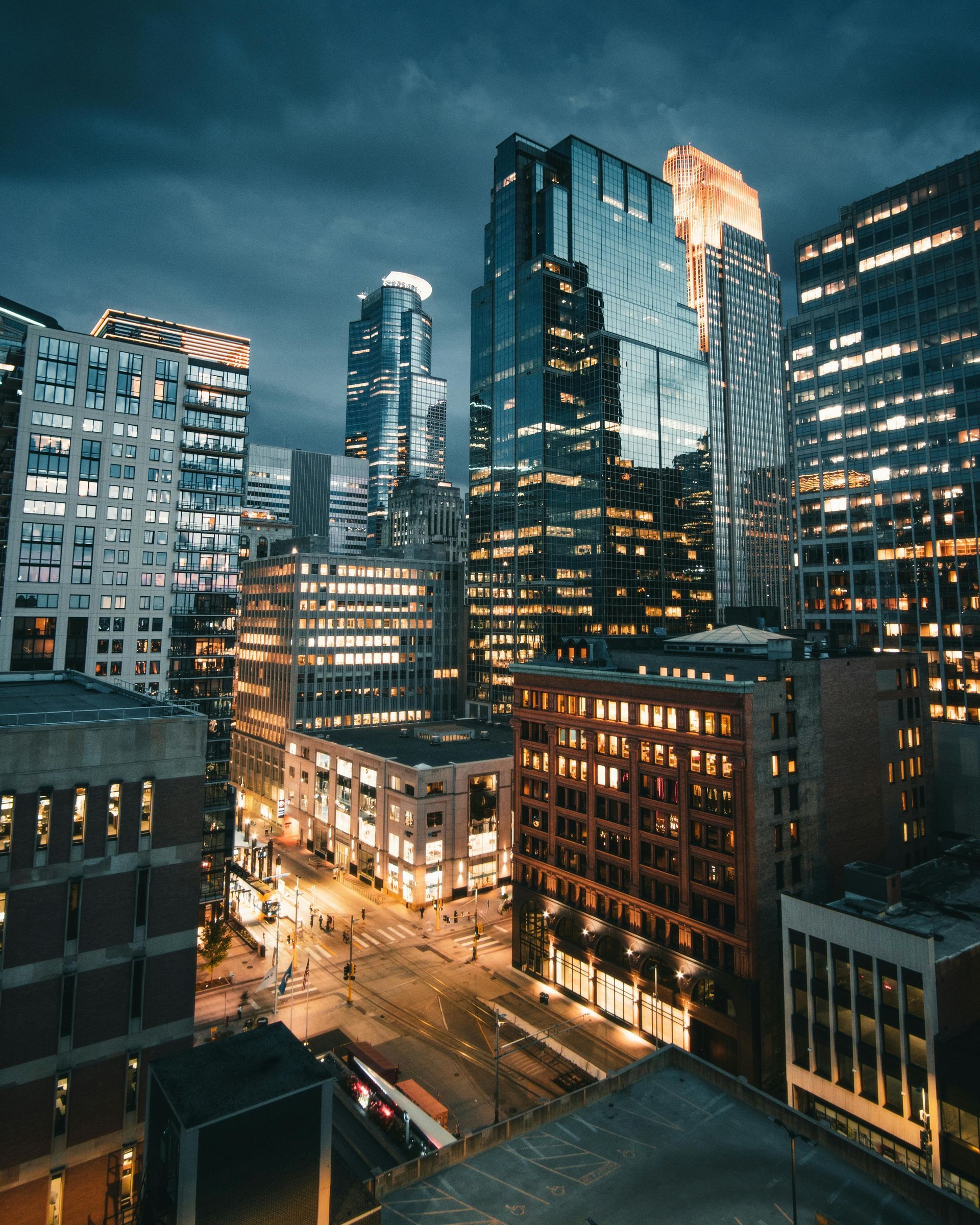 An aerial view of a city at night with lots of tall buildings