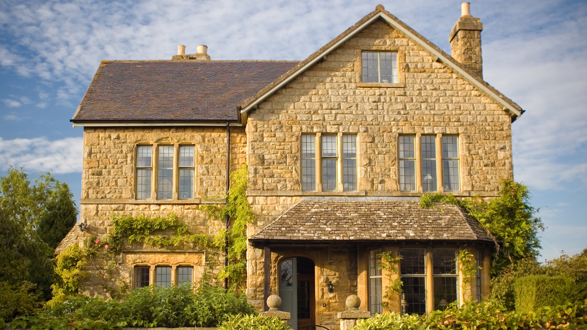 A man is painting the ceiling of a room with a paint roller.