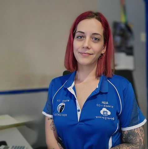 A woman with red hair is wearing a blue shirt that says Winner and Co Bookkeeping.