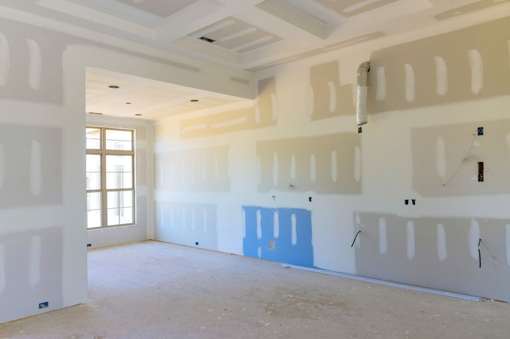 Interior room under construction, with drywall partially installed on walls and ceiling.