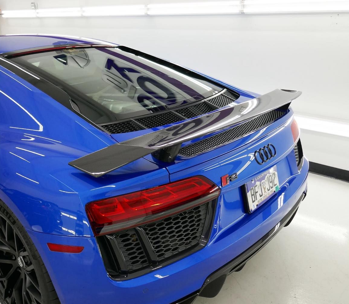 Blue Audi R8 sports car with black spoiler, rear view.