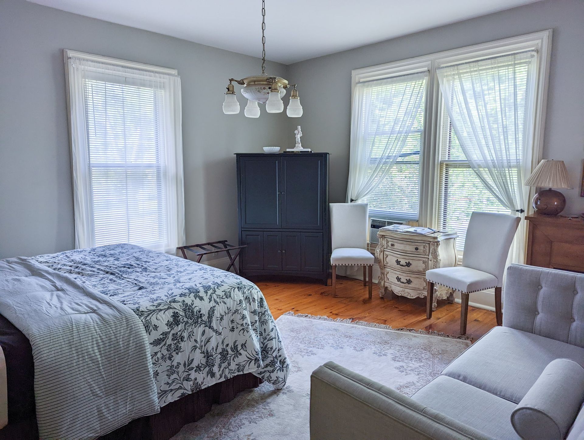 A bedroom with a bed , couch , chairs and a table.