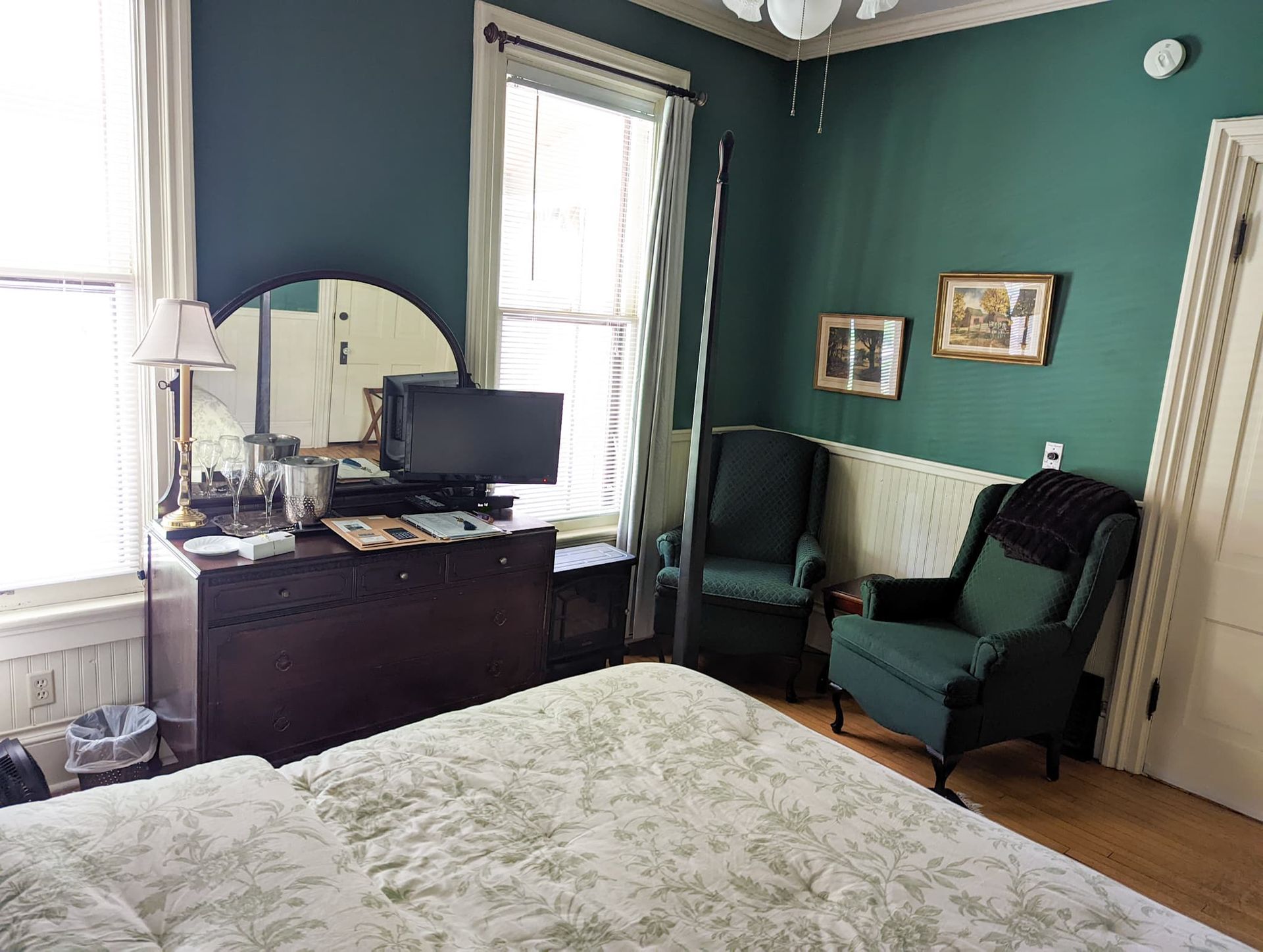 A bedroom with a bed , chairs , dresser and computer.