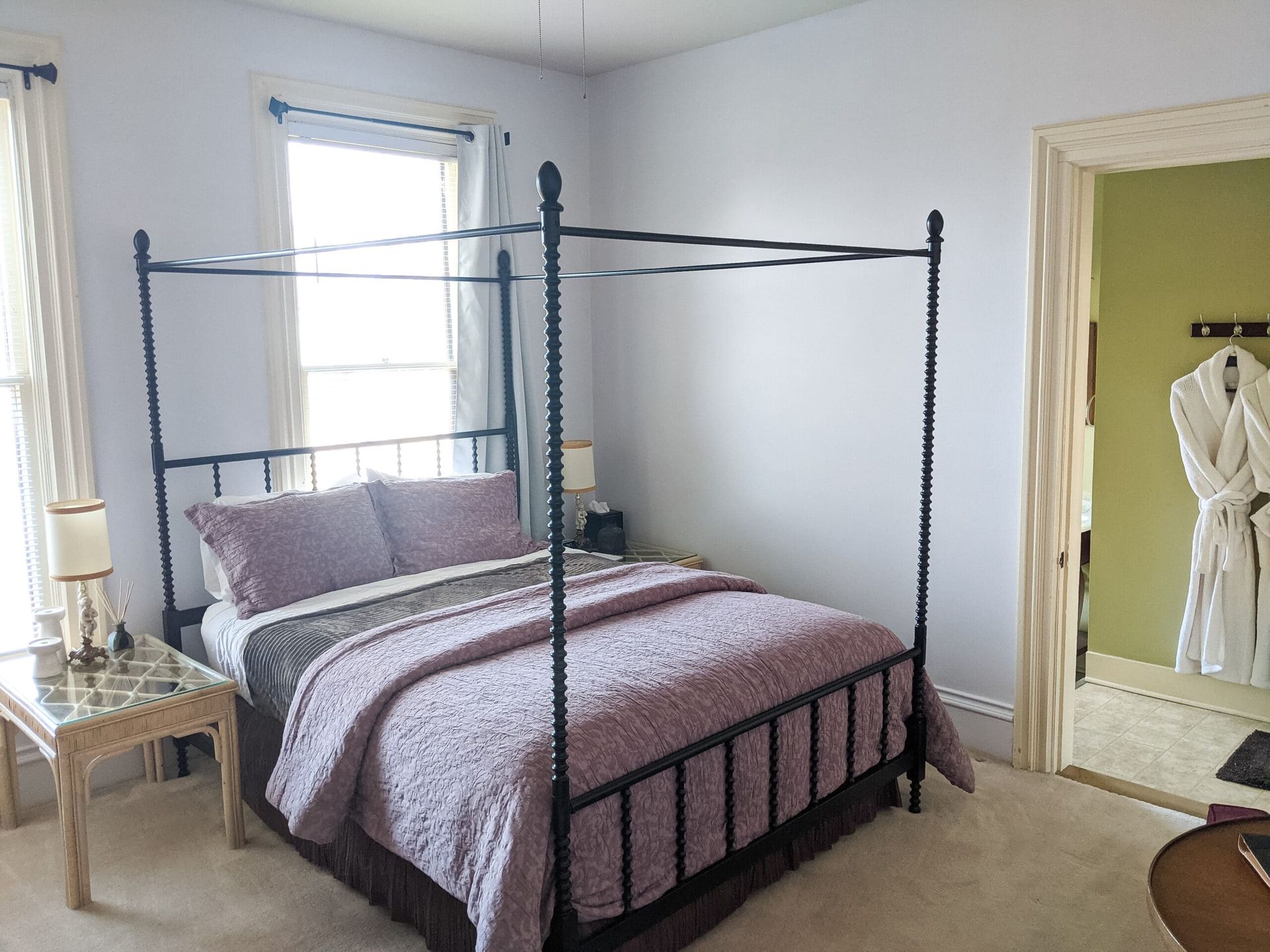 A bedroom with a four poster bed and a window.