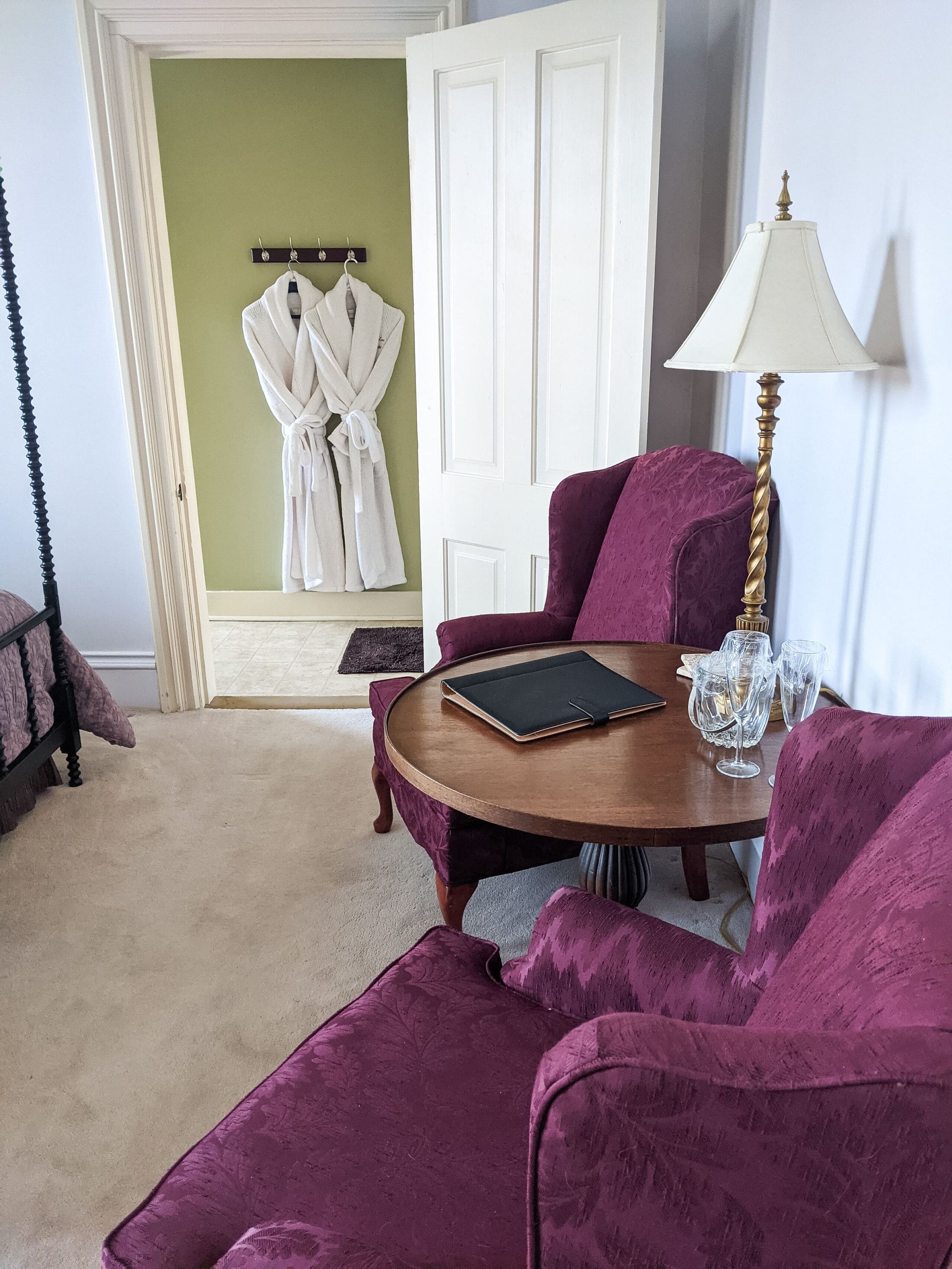 A living room with purple chairs , a table and a lamp