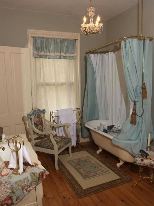 A bathroom with a claw foot tub and a chair