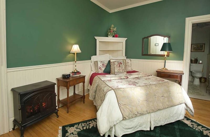 A bedroom with a king size bed and a fireplace