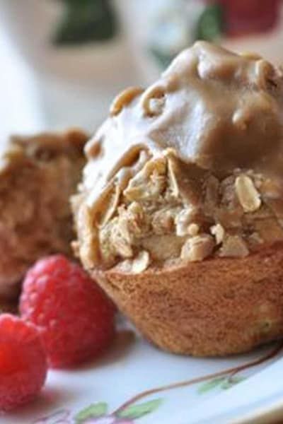 A close up of a muffin on a plate with raspberries