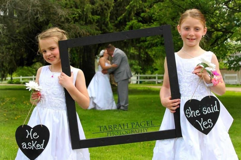 Two flower girls holding signs that say he asked and she said yes