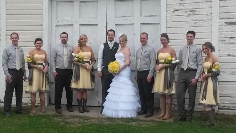 A bride and groom pose with their wedding party