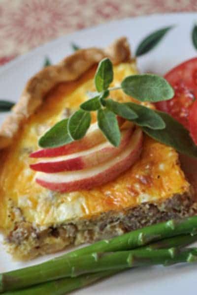 A quiche with apples and asparagus on a plate