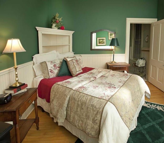 A bedroom with a large bed and green walls