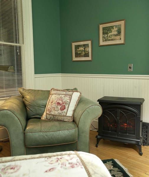 A living room with green walls and a green chair