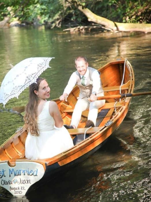 A bride and groom in a boat that says first married