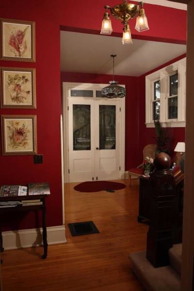 A hallway with red walls and white doors