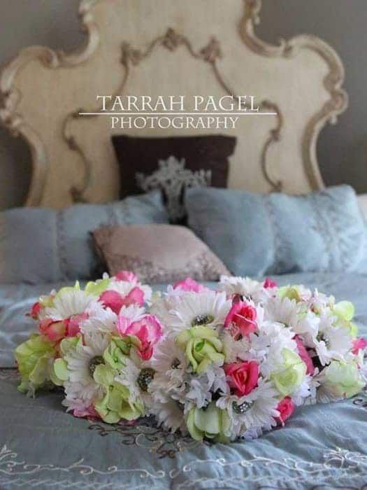 A bouquet of flowers on a bed by tarrah pagel photography