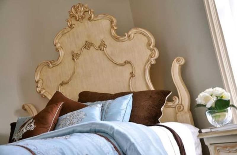 A bed with a headboard and pillows in a bedroom