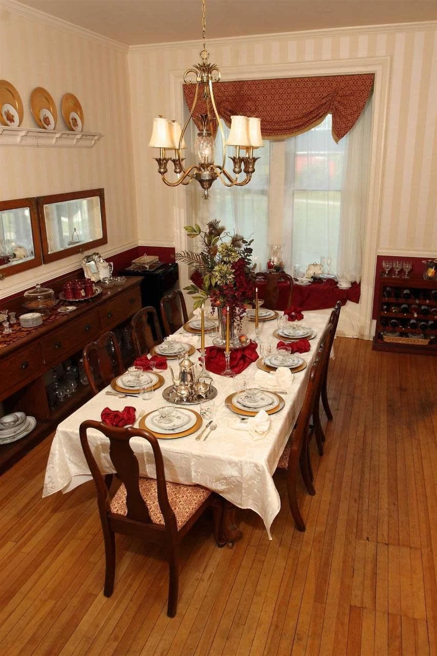 A dining room with a long table and chairs