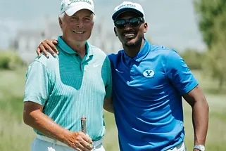 Two men are posing for a picture on a golf course.