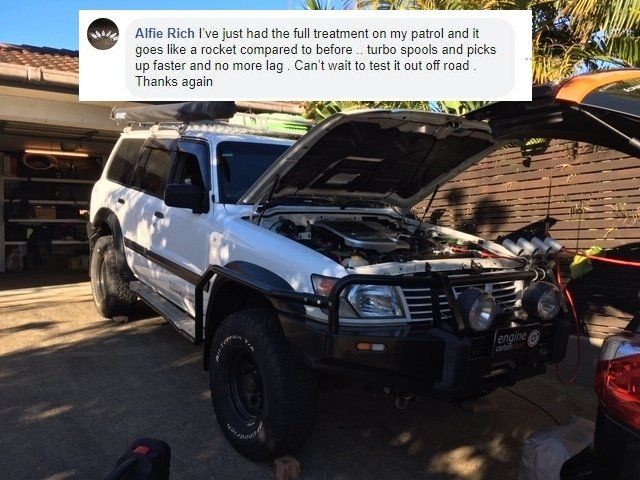A white suv with the hood open is parked in front of a garage.