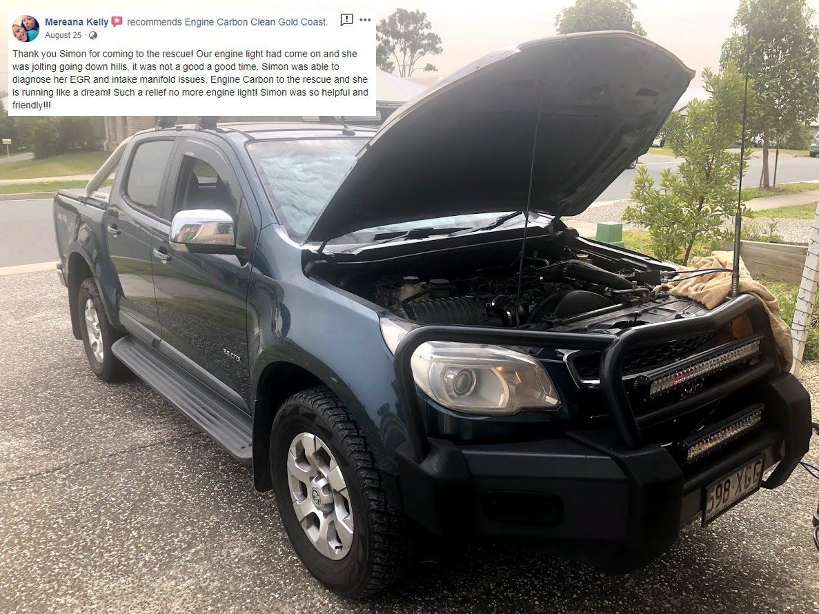 A black truck with the hood up is parked on the side of the road.