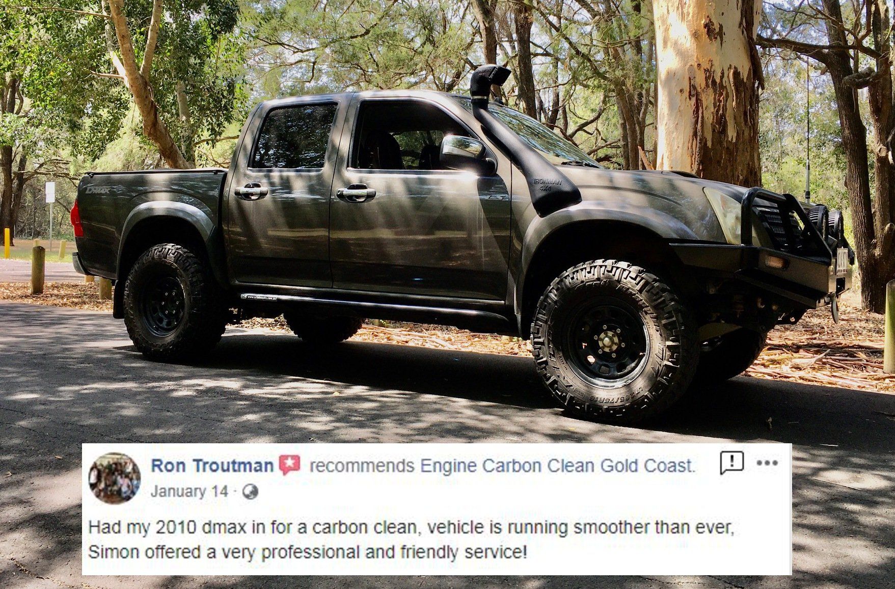 A truck is parked on the side of the road in the woods.