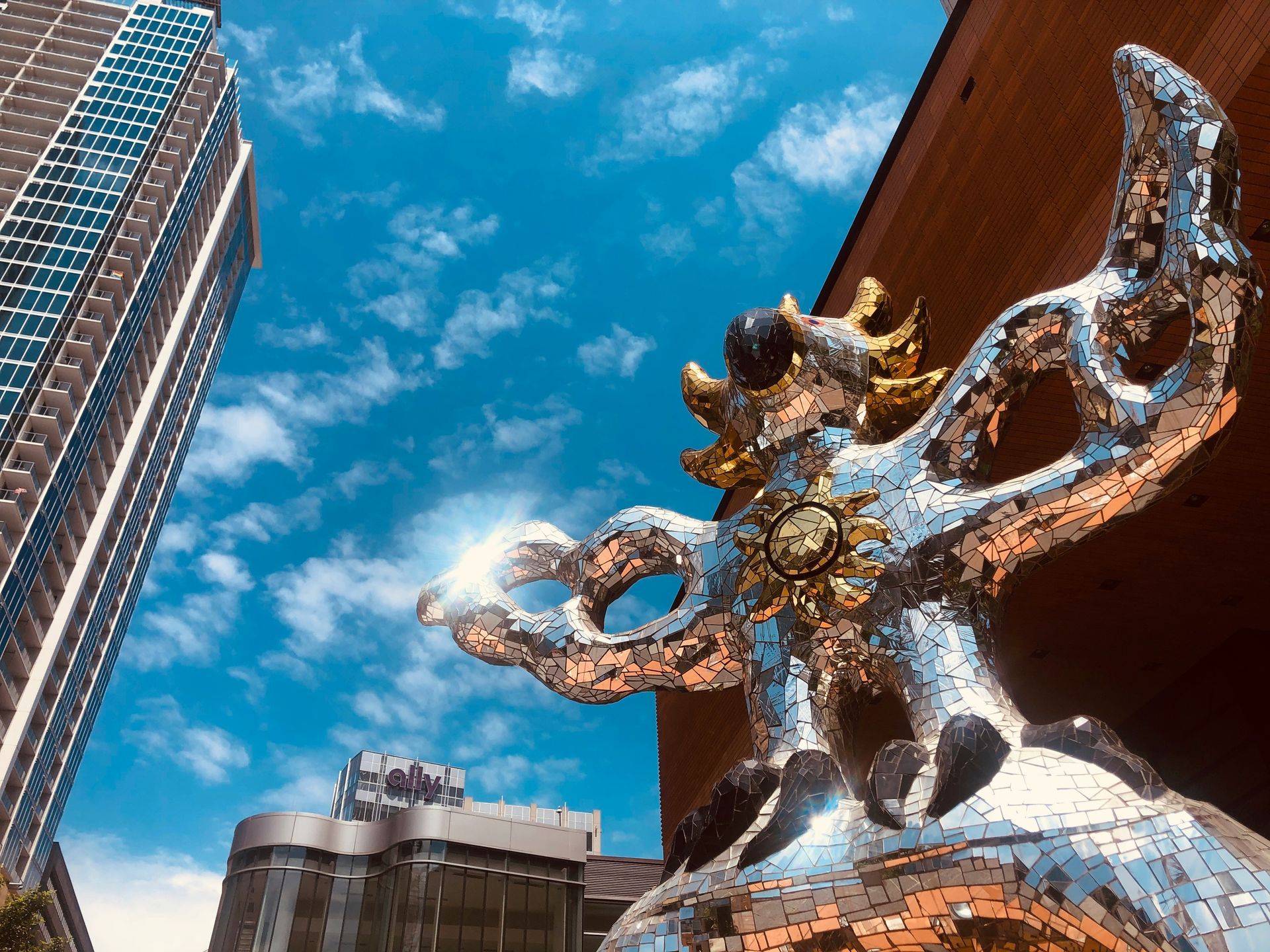 A statue of a dragon is sitting in front of a building in a city.