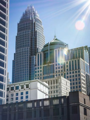 A group of tall buildings with the sun shining through them