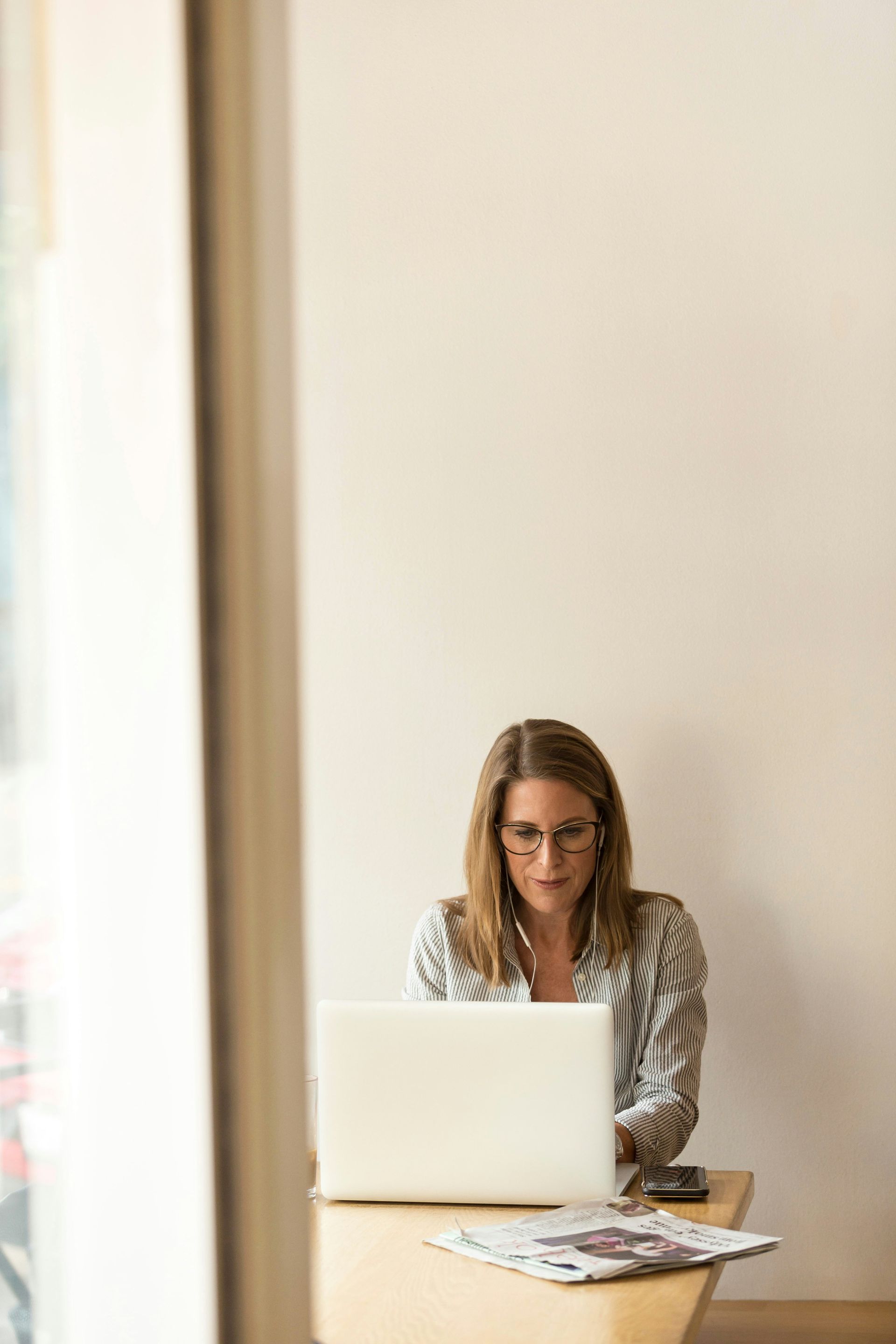 A woman is sitting at a table using a laptop computer.