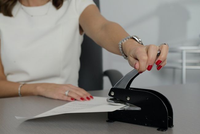 A woman is using a stamp on a piece of paper