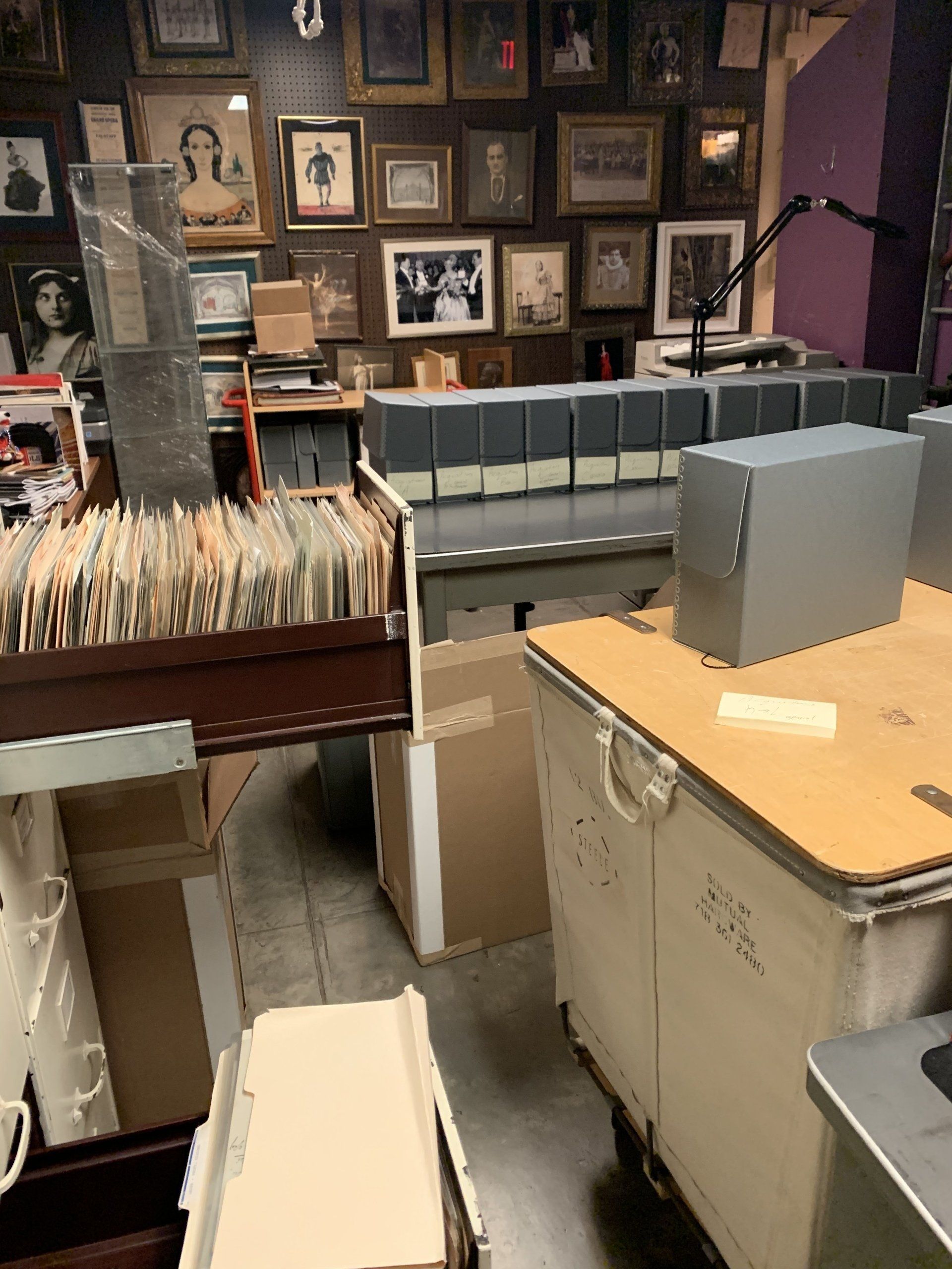 Interior of a cluttered shop filled with framed photos, filing cabinets, and record albums.