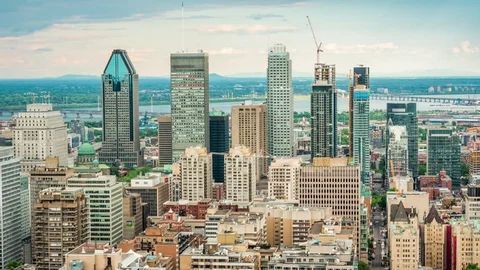 La silhouette de Montréal, avec ses gratte-ciel modernes se détachant sur un ciel nuageux.