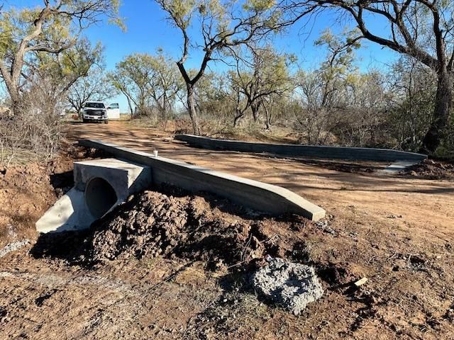 A concrete bridge is being built over a dirt road.