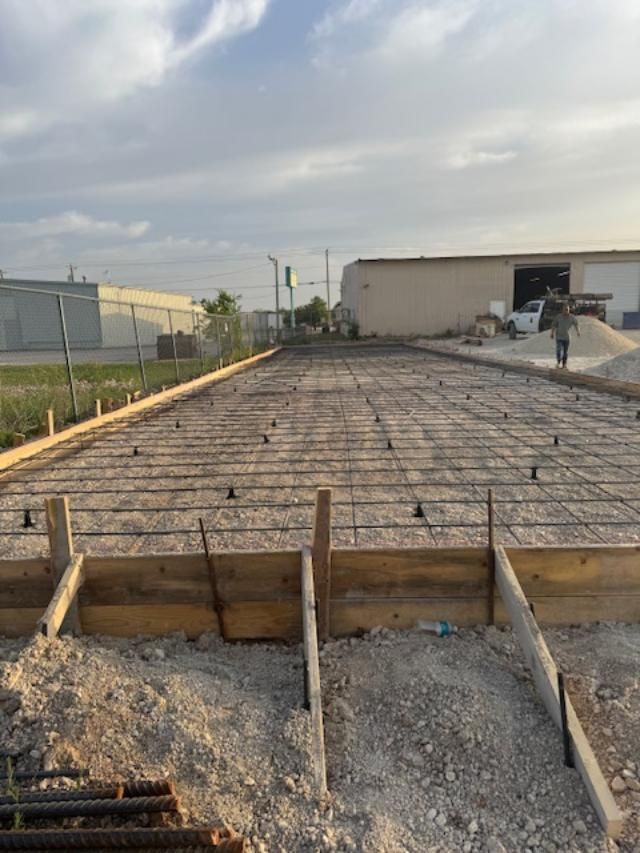 A concrete foundation is being built in front of a building.