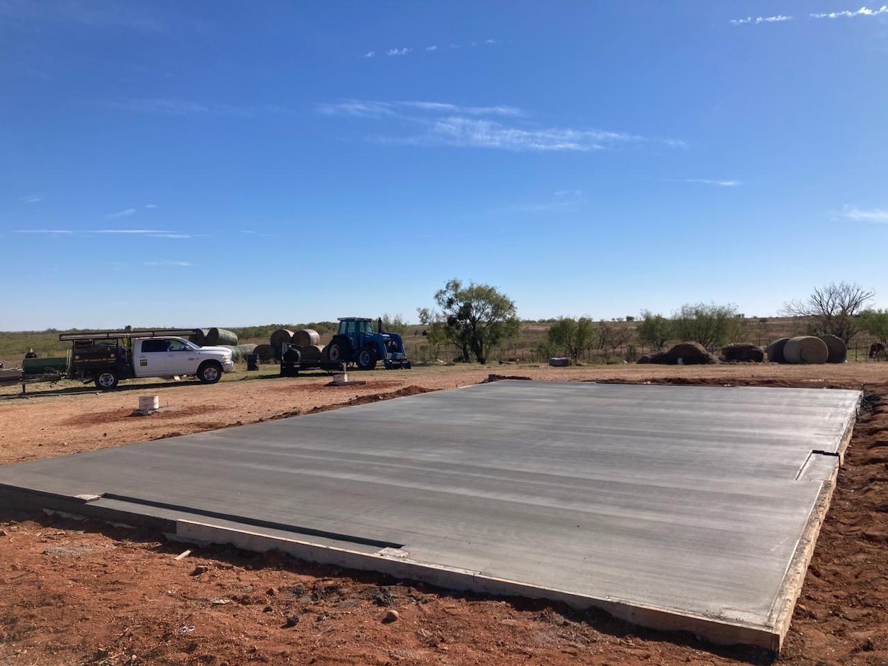 A large concrete slab is sitting in the middle of a dirt field.
