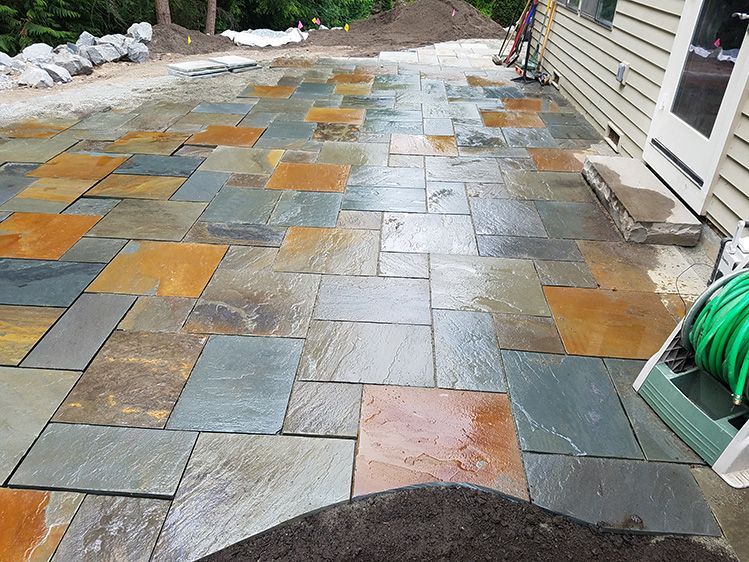 A patio is being built in front of a house.