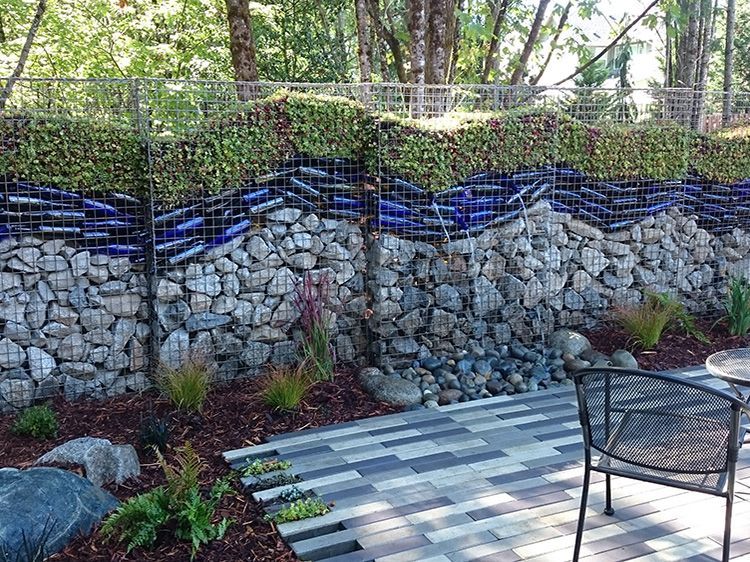 A patio with a table and chairs in front of a stone wall.