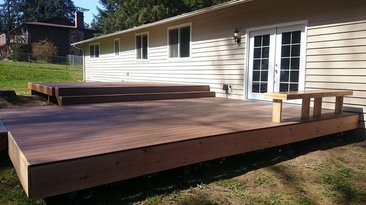 A house with a large wooden deck in front of it