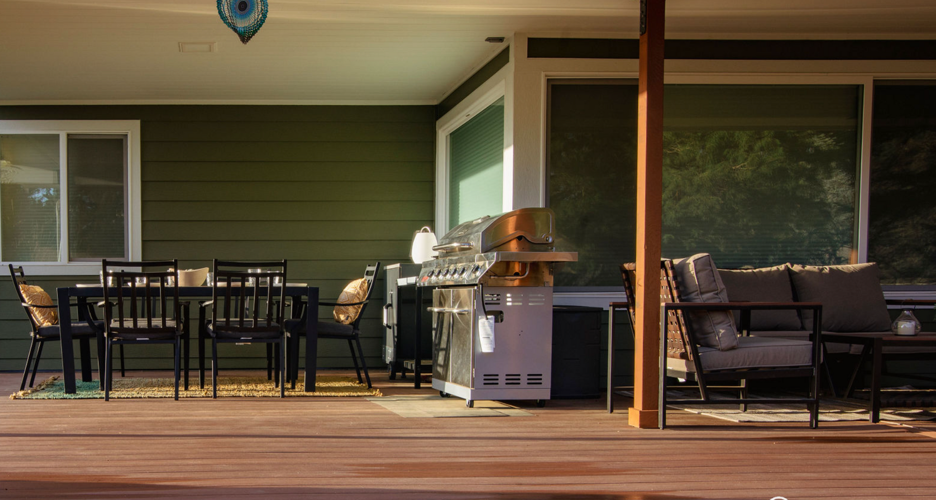 A patio with a table and chairs and a grill.