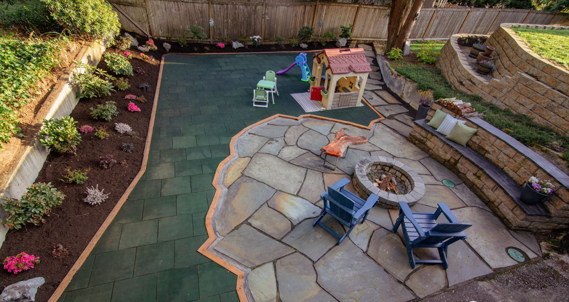 An aerial view of a backyard with a fire pit and chairs.