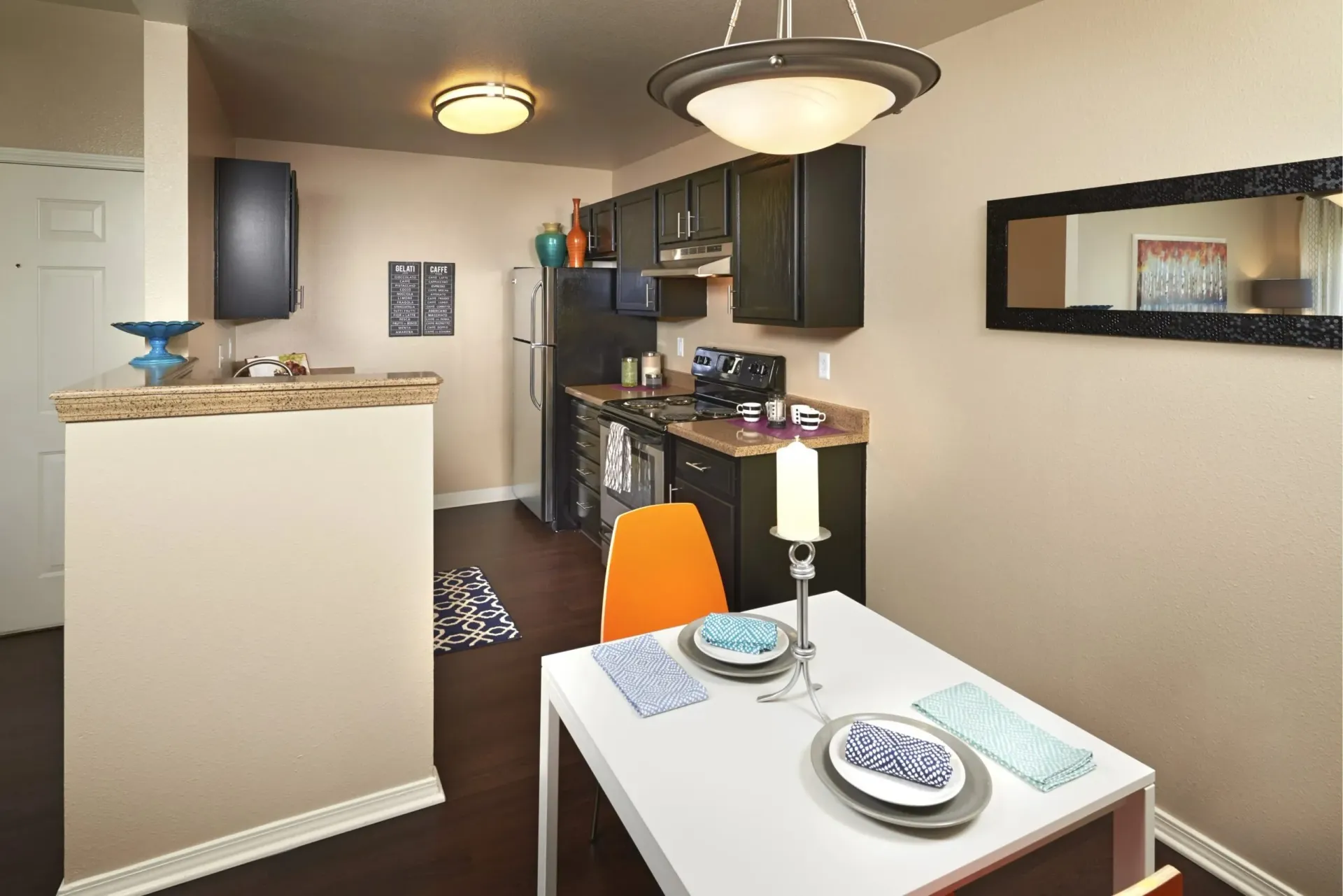 Kitchen and dining area with dark cabinets, granite countertops, and a white dining table.
