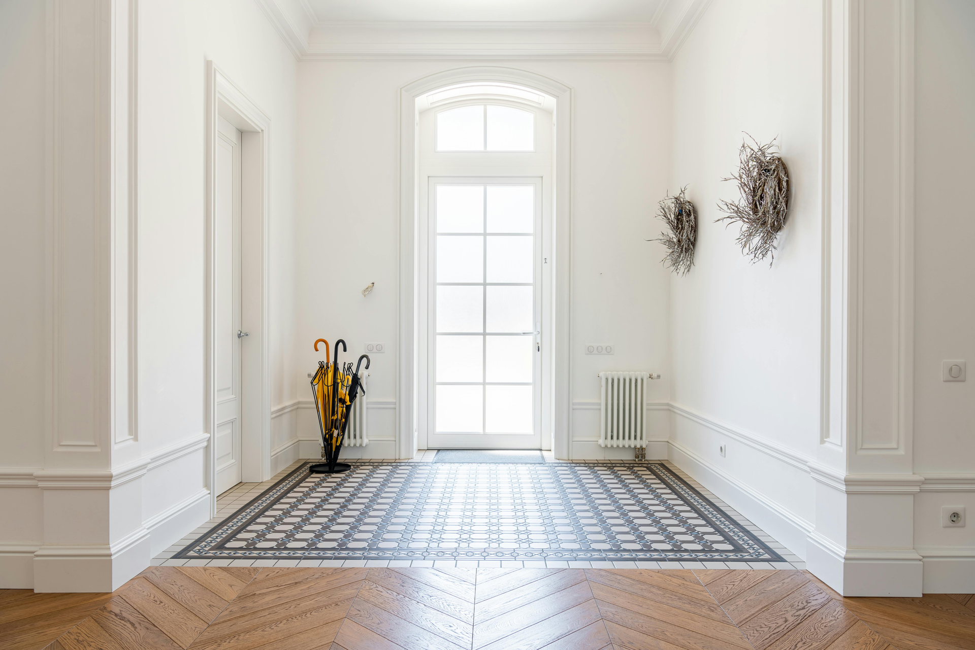 Hallway with wood floor, bench, jacket, and coat rack.